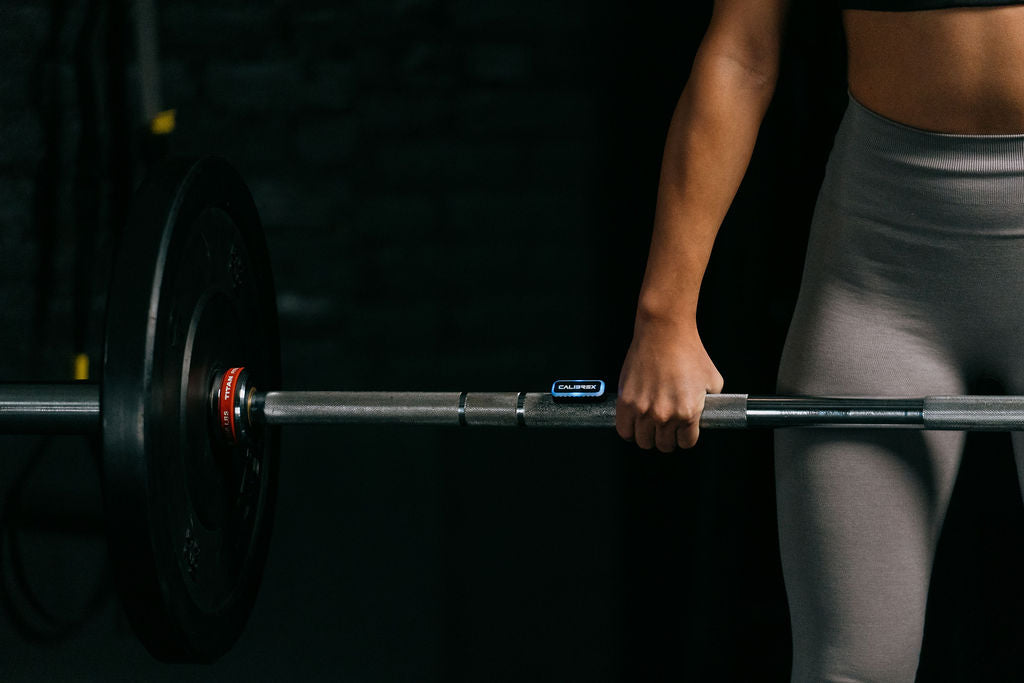 Woman performing deadlift with Calibrex attached on the barbell.